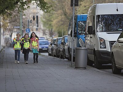 Kinder mit gelben Warnwesten auf dem Schulweg